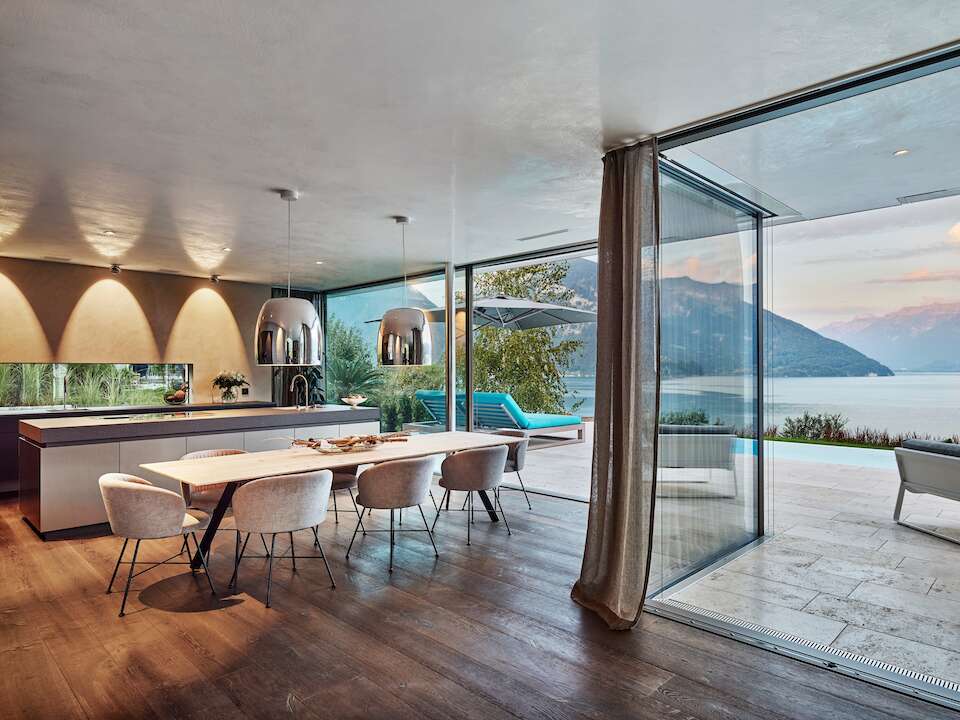Spacious living area with sliding windows overlooking Lake Thun