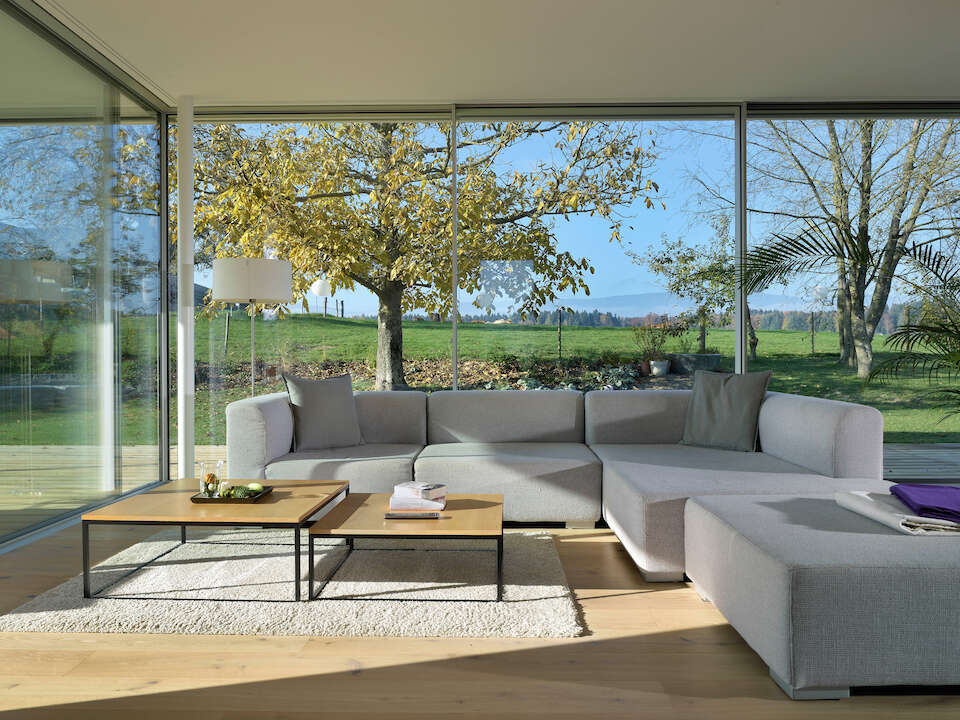 Living room with frameless windows offers 360° views of the natural surroundings