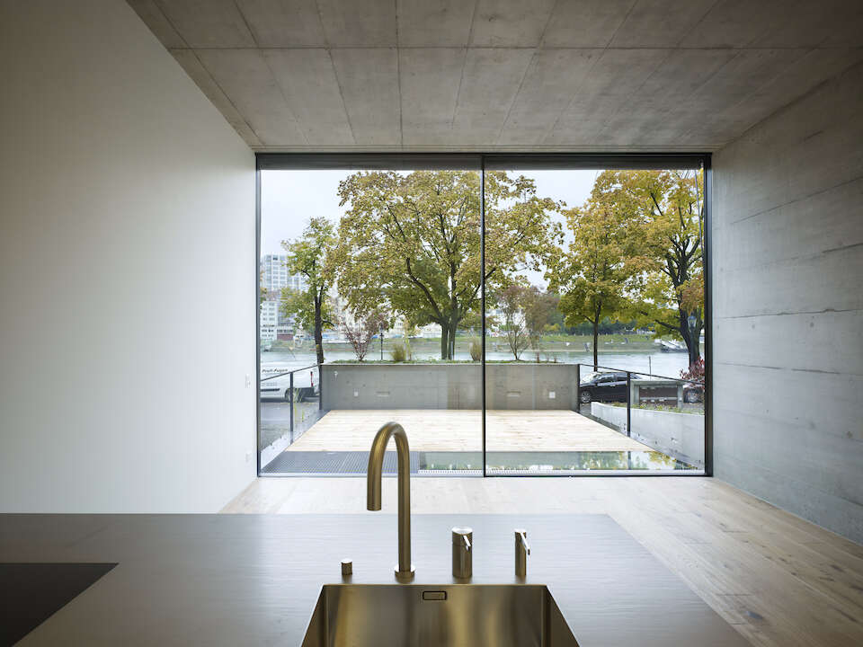 Kitchen in a concrete house with large, frameless sliding windows