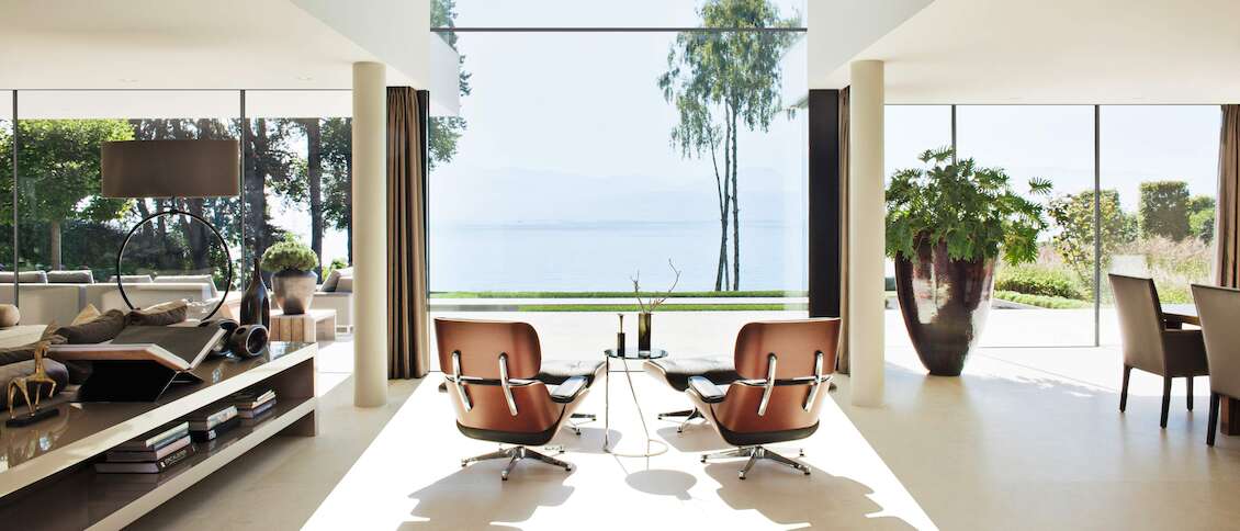 Living room in a Bauhaus villa with window façade and lake view